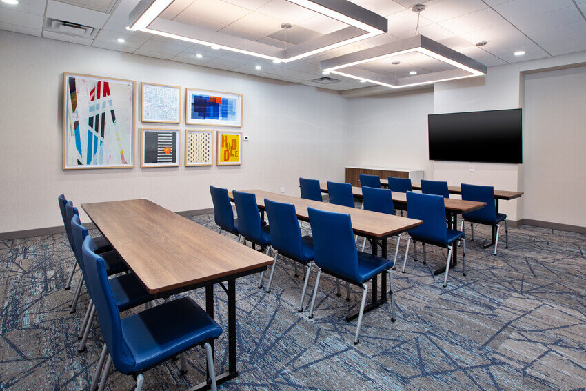 a room with tables and blue chairs