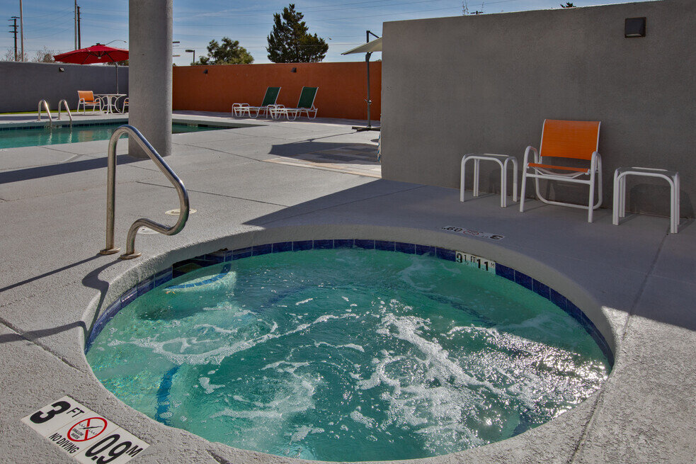 a hot tub with a chair and a wall