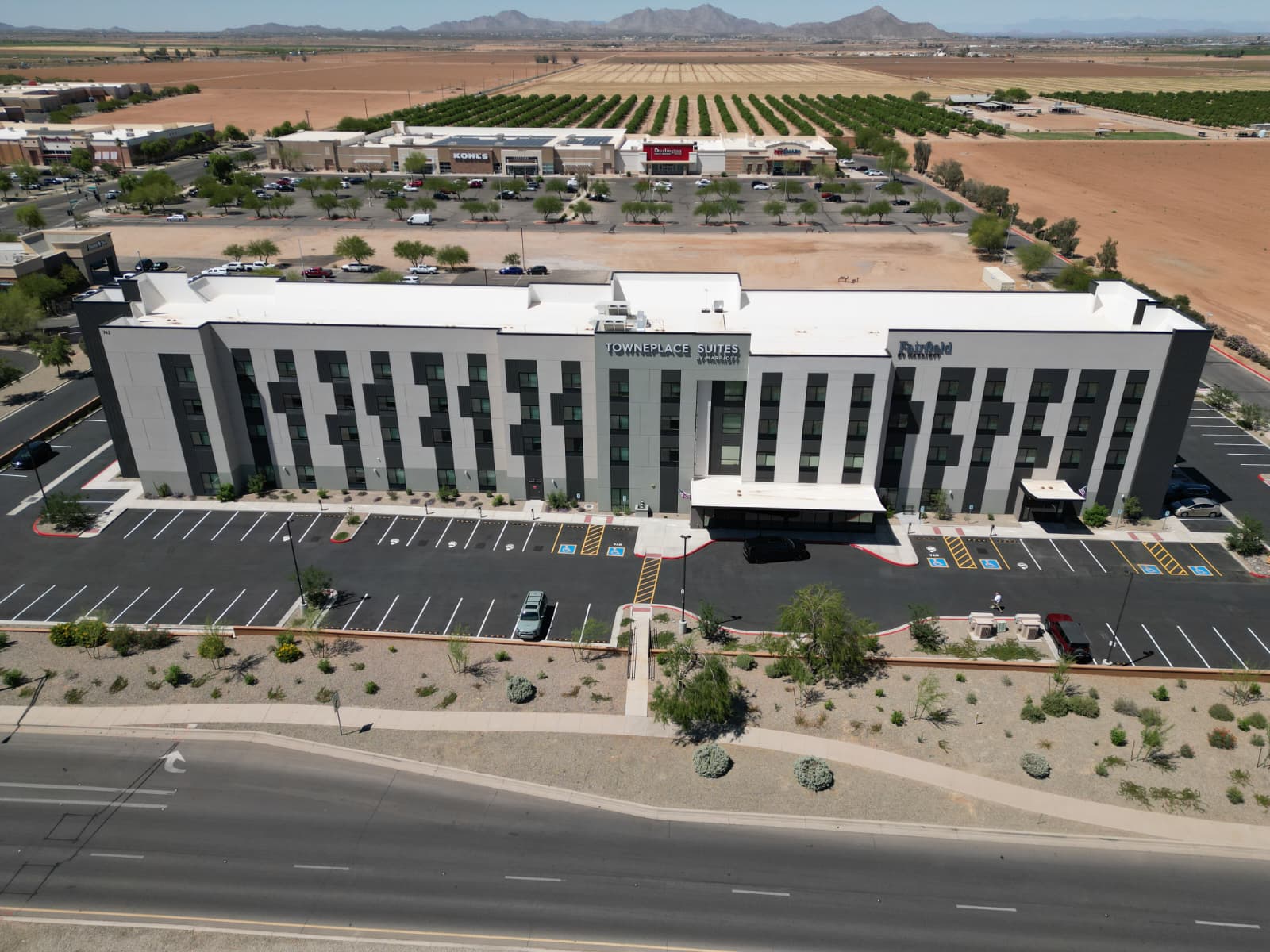 a building with parking lot and a large field